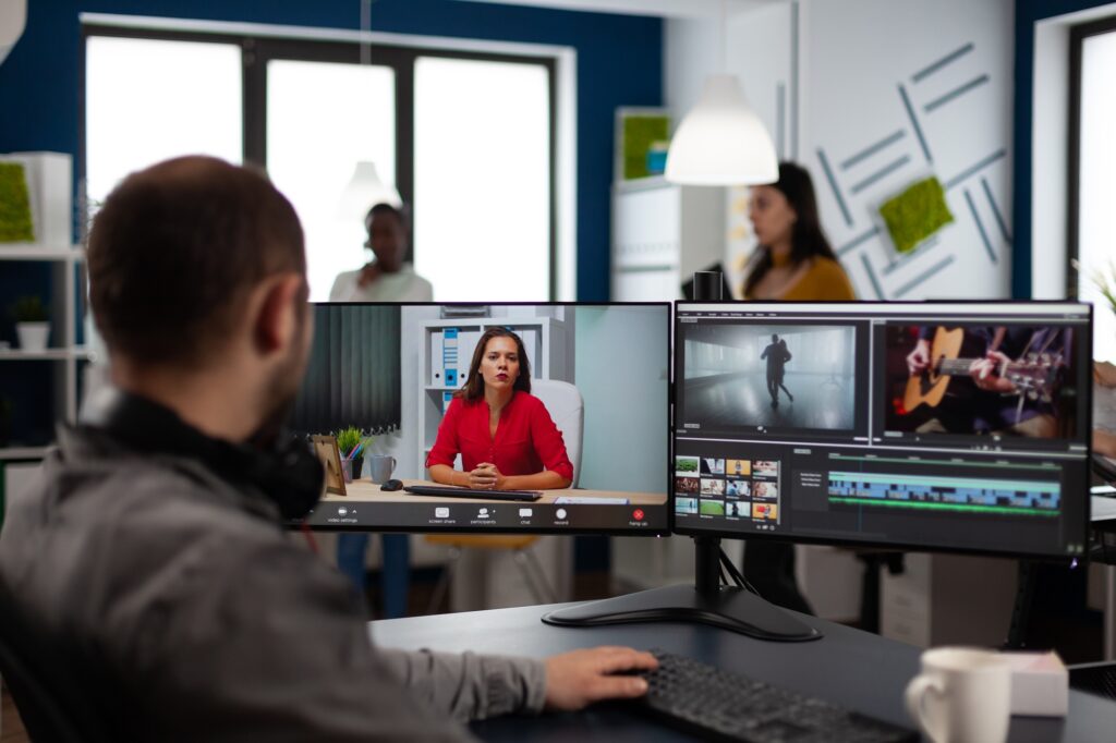 Editor de video en producción web en línea durante una conferencia con el gerente de proyecto en videollamada.