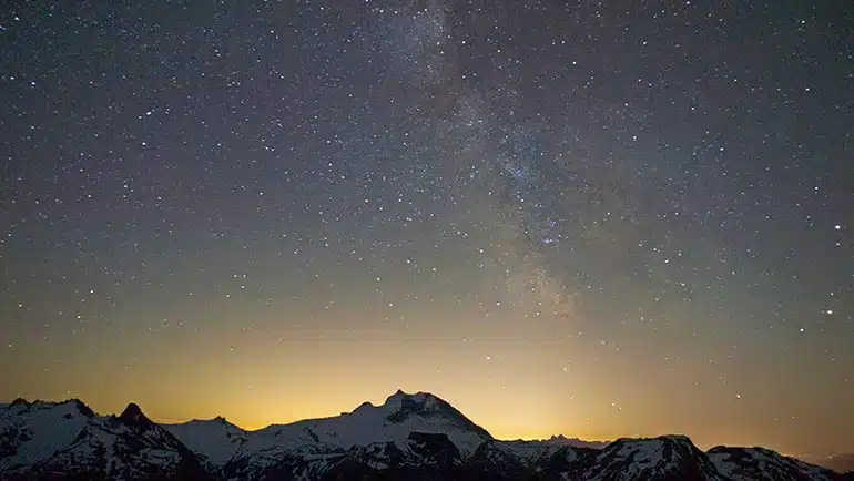 Paisaje nocturno con montañas y cielo estrellado, imagen inspiradora utilizada en demo reel de videos corporativos para transmitir grandeza y profesionalismo en producciones audiovisuales.