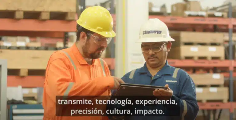 Técnicos industriales de Schlumberger revisando procedimiento en tablet durante capacitación interna grabada en video corporativo.