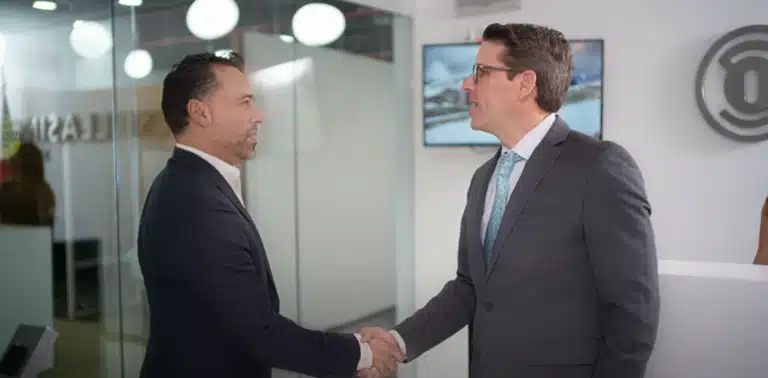 Ejecutivos estrechando manos en oficina moderna durante grabación de video corporativo para ventas B2B en Ciudad de México.