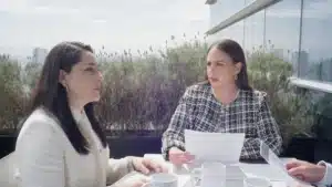 Reunión de trabajo entre profesionales en terraza corporativa con documentos